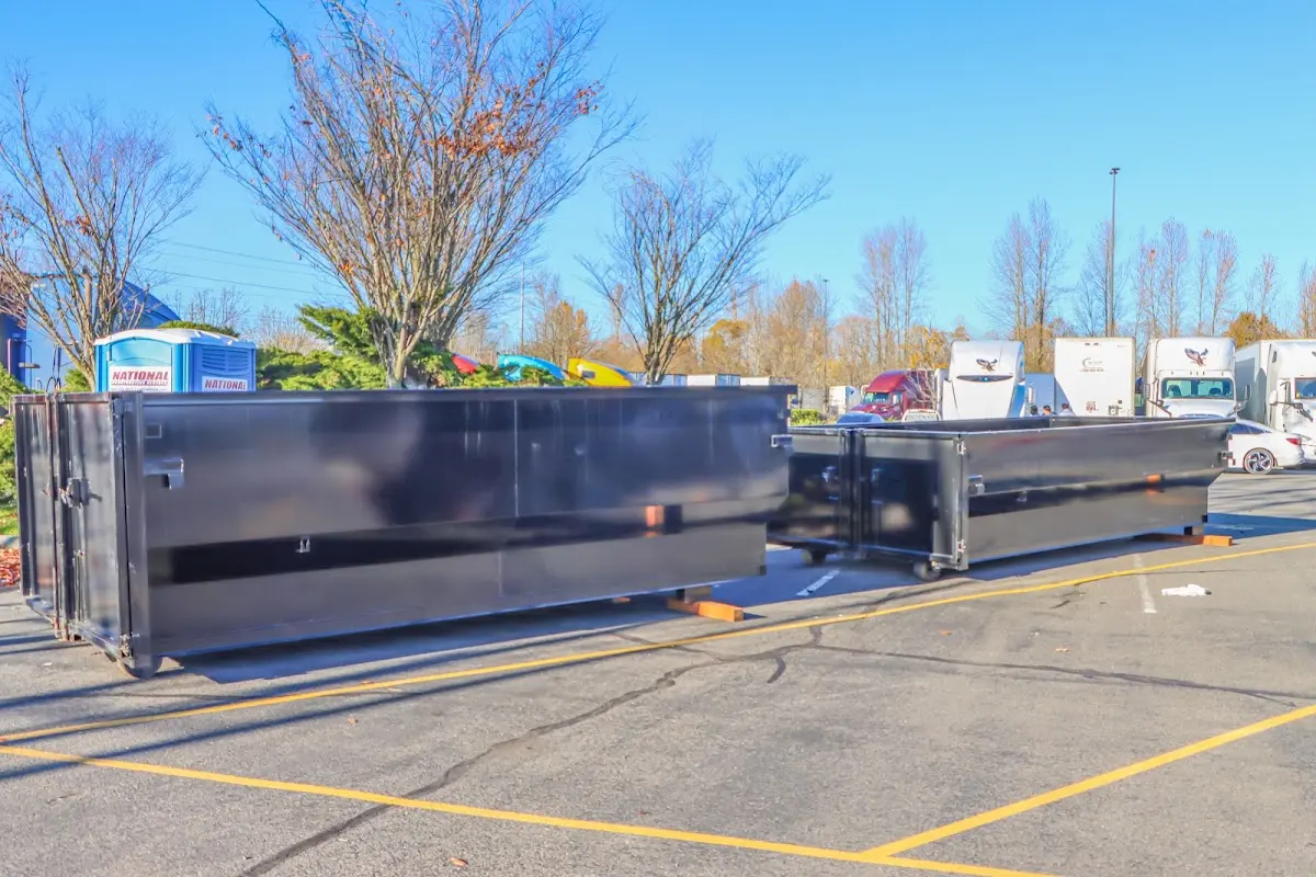 Professional dumpster rental service with roll-off container on residential driveway in Plantation